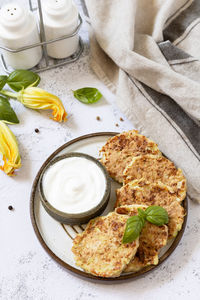 Zucchini fritters. vegetarian zucchini pancakes with cheese, served with sour cream 