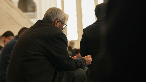 Rear view of man standing against wall