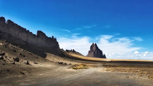 Rock formations on landscape against blue sky