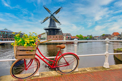 Bicycle by river against buildings