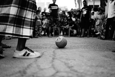Close-up of people playing soccer ball on street