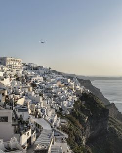 High angle view of buildings and sea against clear sky