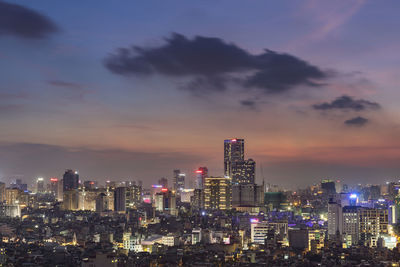 Illuminated buildings in city against sky at night