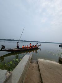 People on boat in sea against sky