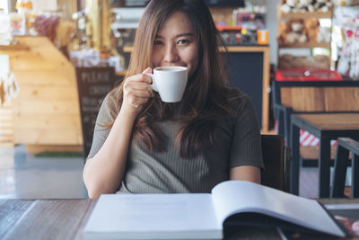 Portrait of woman drinking coffee in cafe