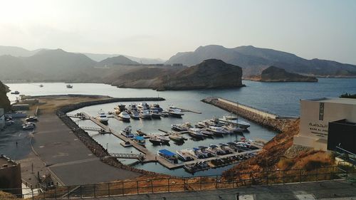 High angle view of boats at harbor against mountains