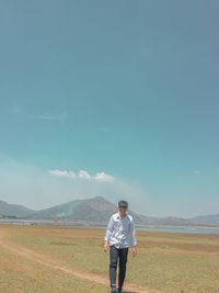 Full length of man standing on field against sky