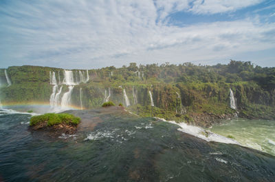 Scenic view of waterfall against sky