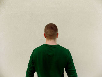 Rear view of man standing against wall