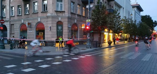 People walking on city street during rainy season