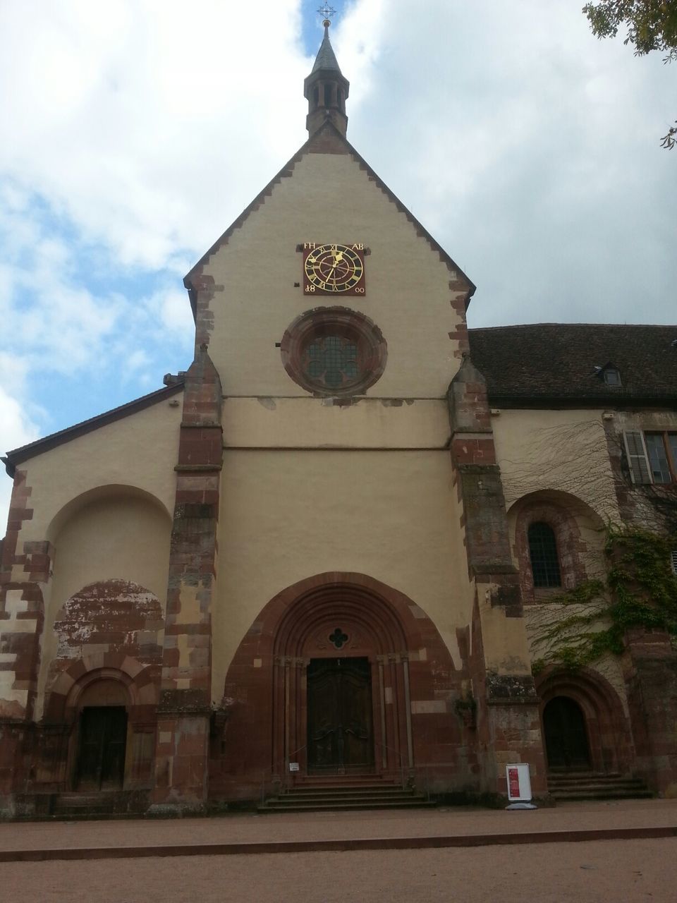 architecture, building exterior, built structure, religion, church, place of worship, spirituality, low angle view, sky, facade, cross, arch, entrance, cloud - sky, cathedral, cloud, window, day