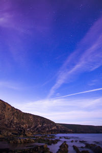 Scenic view of snowcapped mountains against blue sky at night