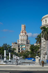 Buildings in city against clear blue sky