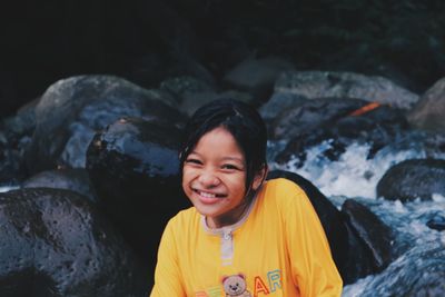 Portrait of smiling gilrs on rock