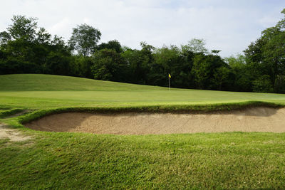 Scenic view of golf course against sky