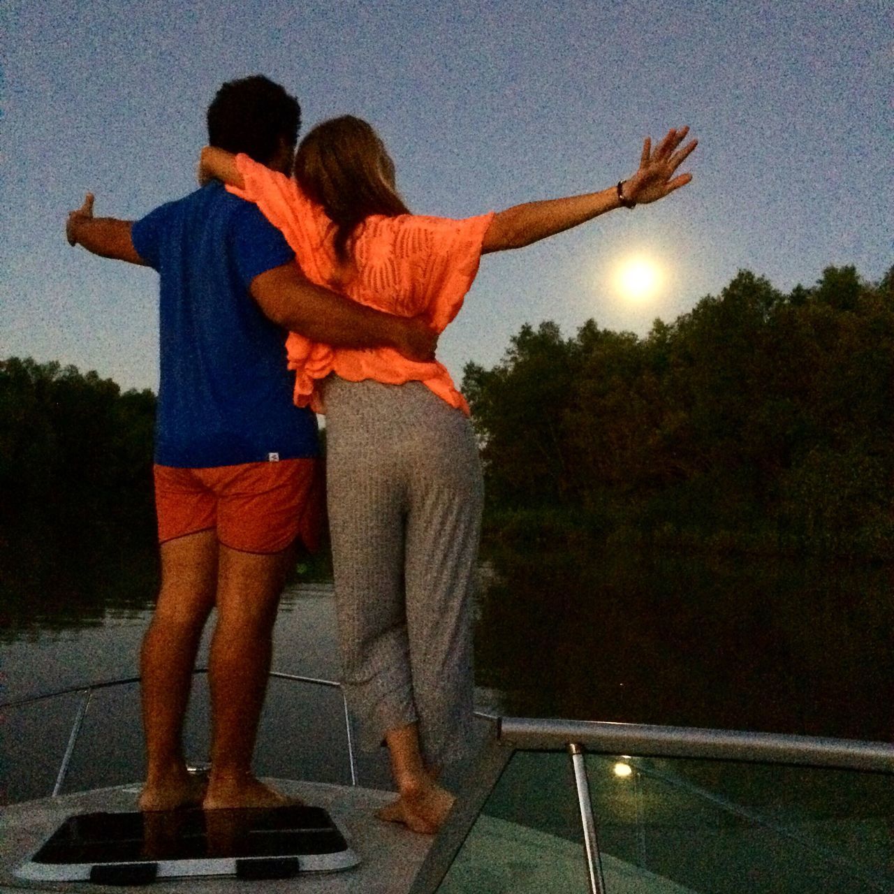 two people, togetherness, heterosexual couple, love, leisure activity, standing, men, couple - relationship, rear view, casual clothing, real people, outdoors, night, women, human body part, friendship, tree, sky, water, nature, people, adult, adults only