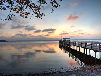 Pier over sea against sky during sunset