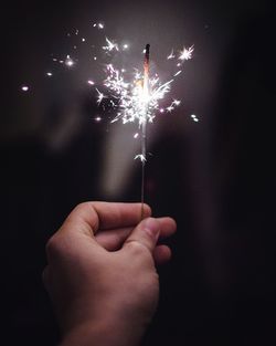 Close-up of hand holding illuminated sparkler