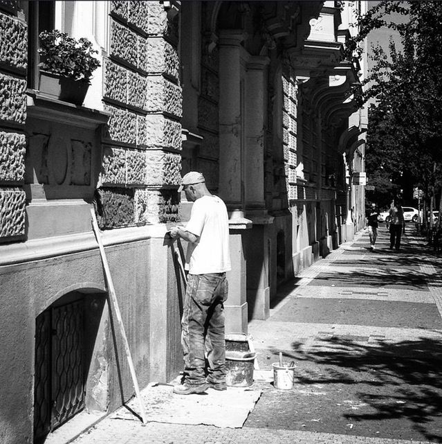 building exterior, architecture, built structure, lifestyles, full length, men, city, walking, rear view, street, leisure activity, casual clothing, person, city life, sidewalk, day, the way forward, cobblestone