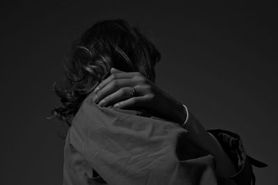 Rear view of woman standing against gray background