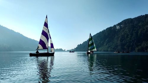 Sailboat on lake against clear sky