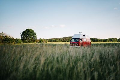 Motor home on grassy field against sky