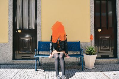 Woman sitting on chair outside building