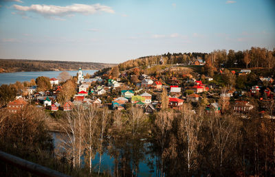 High angle view of buildings by river against sky