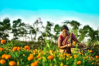 Woman with flowers on field