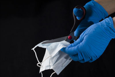 Midsection of man holding umbrella against black background