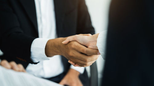 Midsection of businessman shaking hands