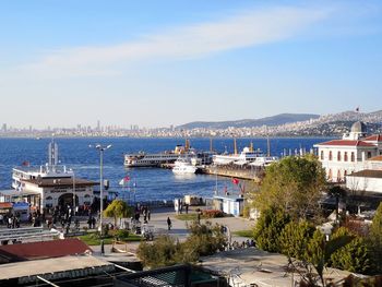 Sailboats in sea against sky in city