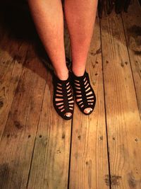 Low section of woman walking on wooden floor