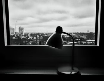 Man looking through window in city