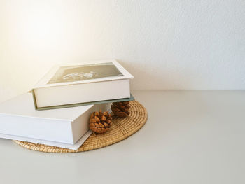 High angle view of open book on table against white wall