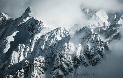 Snow covered mountain range above the clouds in the arlberg region, austria