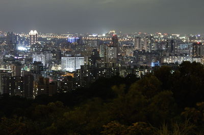 Illuminated cityscape against sky at night