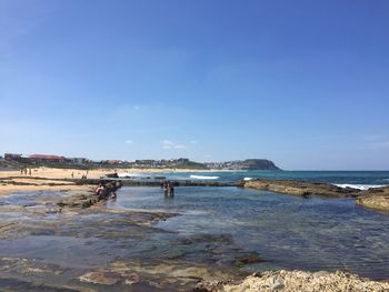 Scenic view of beach against clear blue sky