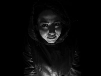 Close-up portrait of cute boy against black background