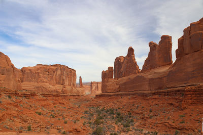 Rock formations on landscape against cloudy sky