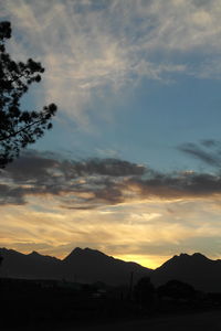 Silhouette of landscape against cloudy sky