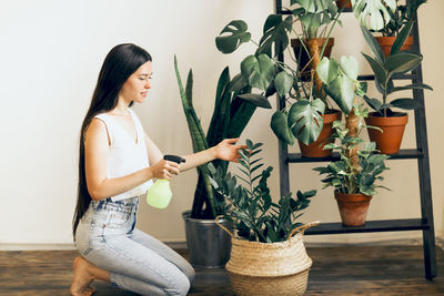 Young woman holding potted plant