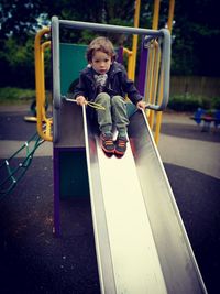 Full length portrait of boy on slide