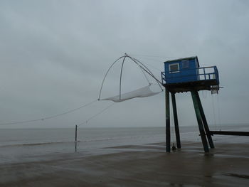 Lifeguard hut on beach against sky