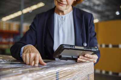 Manager with tablet pc examining in warehouse
