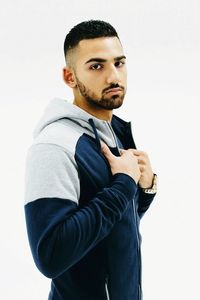Portrait of young man standing against white background