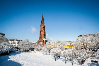 Old church in city against sky during winter