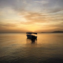 Boat in sea at sunset