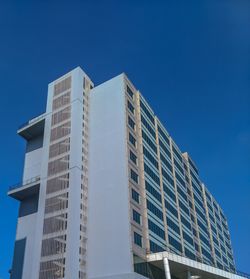 Low angle view of modern building against clear blue sky