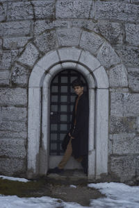 Man standing at doorway during winter